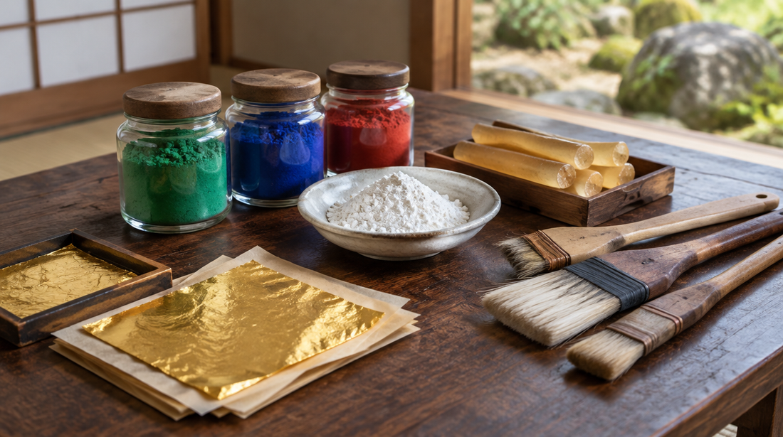 Jars of ground mineral pigments, shell-white powder, glue sticks, brushes and gold leaf on a low table