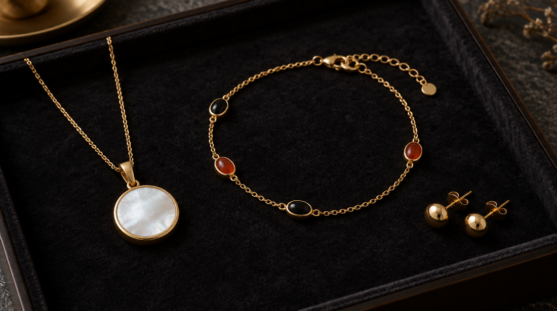 Fine gold jewellery set with mother-of-pearl, onyx and carnelian on a dark velvet tray